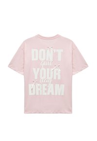 Różowa bawełniana koszulka z krótkim rękawem, z napisem "NIE rezygnuj ze swoich dziennych marzeń" na białym tle, z ozdobnymi białymi kokardkami z tyłu. Luźny krój.