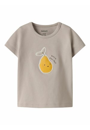 Šviesiai smėlio spalvos vaikiški marškinėliai su geltonos šypsančios kriaušės grafika ir užrašu „tu esi kriaušė-idealas“ priekyje centre.