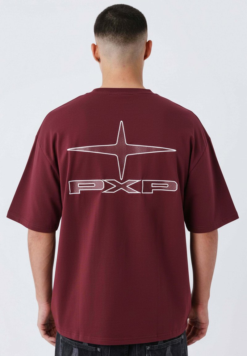 Camiseta de manga corta burdeos con un gran gráfico de estrella blanca y el texto "PXP" en la parte posterior, hecha de una tela suave y lisa.