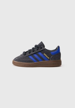 Mørkegrå og blå Adidas-sneaker med gummisåle, snøring foran og gullbokstaver "SPEZIAL" på siden.