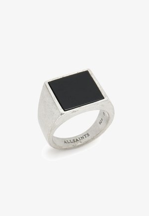 Vierkante zwarte stenen ring gezet in een gestructureerde zilveren band. Eenvoudig ontwerp met gepolijste oppervlakte en gegraveerde merknaam aan de binnenkant.