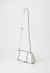 Valkoinen suorakaiteen muotoinen olkalaukku, jossa on säädettävä pitkä hihna ja lyhyet ketjukahvat, aseteltuna neutraalia taustaa vasten.