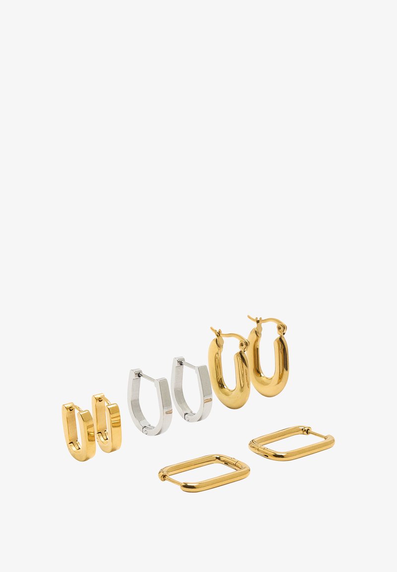 Zestaw czterech par kolczyków: dwa złote owalne kółka, jeden srebrny otwarty pierścień i dwa złote prostokątne kółka. Gładkie wykończenia i polerowane metalowe powierzchnie.