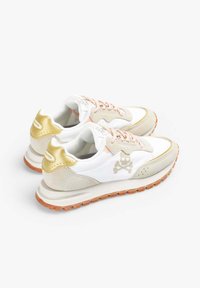 Zapatillas blancas y beige con detalles dorados, cordones rosa claro, material texturizado, suela de goma y diseño de calavera en el lateral.