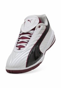 Hvide sneakers med glansfulde sorte detaljer og burgunder elementer, der har en tekstureret overdel, polstret tunge og fremtrædende snørresystem.