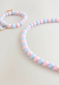 Szilikon ékszerszett, amely egy rózsaszín és kék gyöngy nyakláncból és karkötőből áll, sima textúrákkal és kerek formákkal.