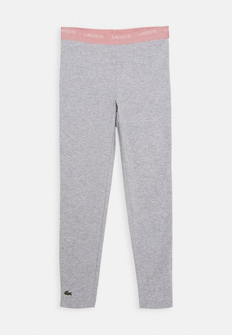 Szare legginsy z różowym elastycznym paskiem w talii, na którym znajduje się napis "LACOSTE" oraz zielony logo krokodyla umieszczone blisko dolnego szwu na lewej nodze.