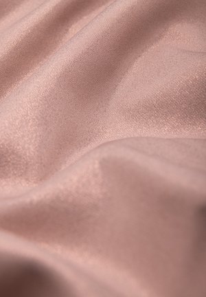 Miękka, gładka, bladoróżowa tkanina z delikatnymi fałdami i subtelnym połyskiem odbijającym światło.