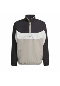 Svart, vit och beige Adidas-pulloverjacka med en fjärdedels dragkedja, hög krage, elastiska ärmslut och sidofickor.