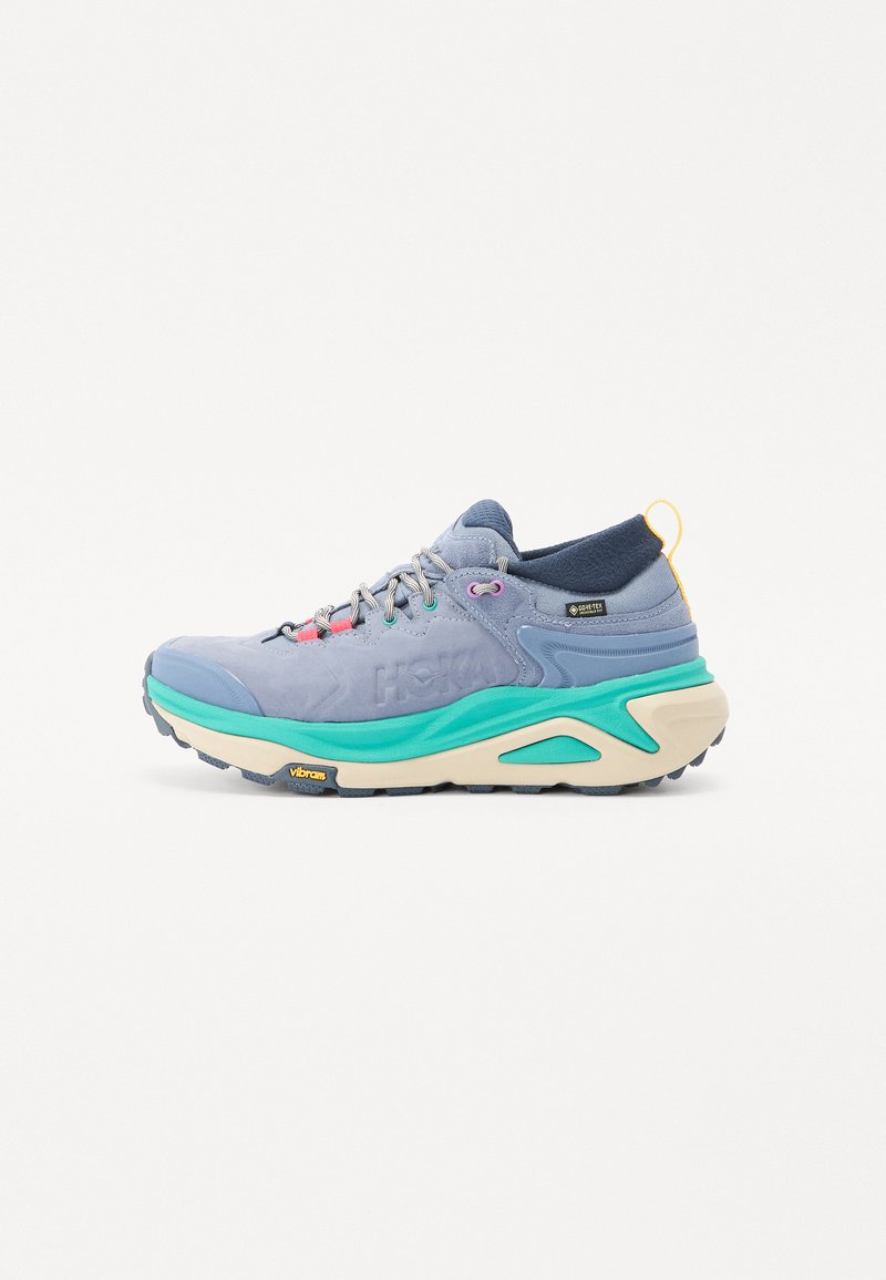 Scarpa da trekking blu e verde acqua con tomaia texturizzata, suola in gomma, lacci colorati e tacco pronunciato con linguetta. Logo Vibram visibile.