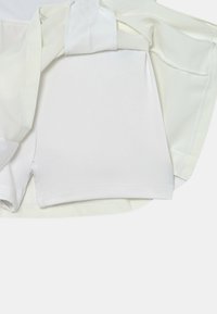 Pantalones cortos deportivos blancos con un forro interior ajustado y una cinturilla texturizada, que presentan una tela lisa y un diseño simple.