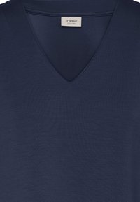 Granatowy shirt z dekoltem w serek z wszytą metką marki Fransa wewnątrz kołnierza.