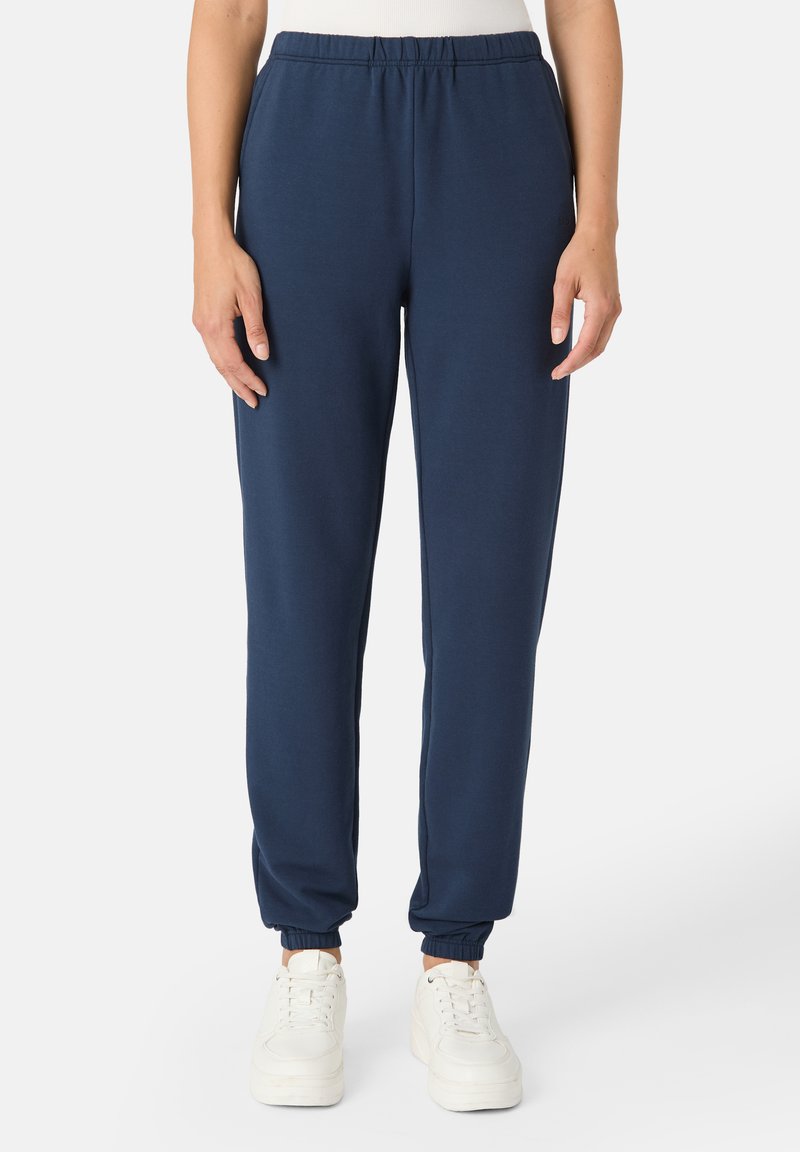 Námořnické modré tepláky vyrobené z bavlněné směsi, s elastickým pasem a manžetami, hladkou texturou a zúženými nohavicemi.