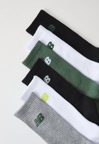 Kuu paari sokke, esitatud: mustad, valged, rohelised, hallid, ribatud tekstuuriga ja kontrastsetes värvides logo mustriga igal sokil.