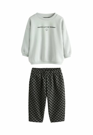 Hellgrauer Hoodie mit dem Text "HAPPY LITTLE HUMAN", kombiniert mit schwarz-grauen karierter Shorts, elastischem Bund, aus weichem Material.