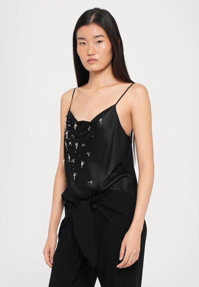 Mustak satin camisole, jossa on roikkuva kaula-aukko, koristeltu hopeisilla yksityiskohdilla; ohut olkaimet ja löysä istuvuus.