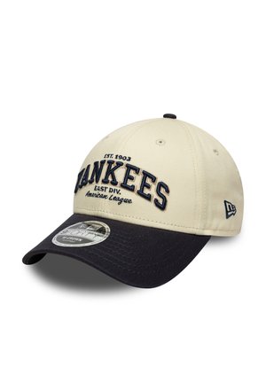 Beige Mütze mit navyfarbenem Schirm, bestickt mit dem Text "Yankees" in Blau, Gründungsdatum und Ligadetails. Strukturierte Gestaltung mit Belüftungslöchern.