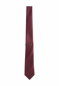 Burgundy nyakkendő, texturált anyagból készült, középen egy elegáns ezüst nyakkendőtűvel és hegyes csúccsal.