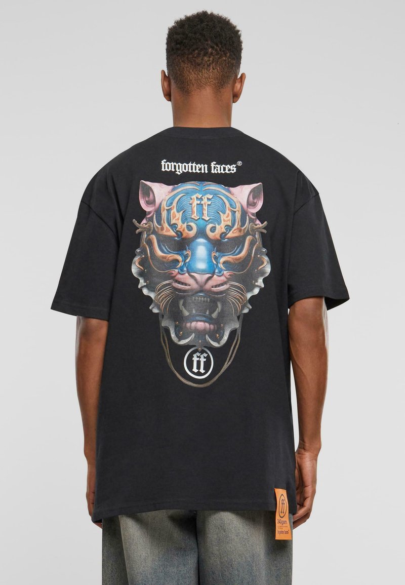 Sort bomulds T-shirt med et farverigt grafik af et løvehoved med blå accenter på ryggen og et logo mærke ved kanten.