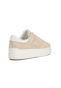 Light beige suede sneakers with white rubber sole, round toe, and flat laces. Features minimal stitching and subtle logo detail on the side.