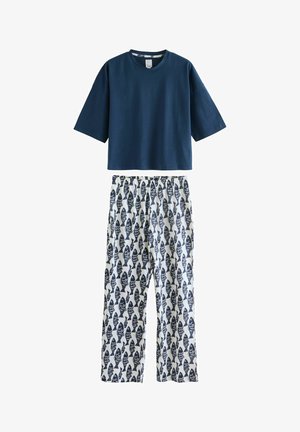 Top albastru marin cu mâneci scurte asortat cu pantaloni albi largi, având un model repetitiv cu pești de culoare albastru închis.