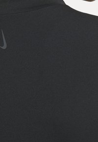 Sort atletisk skjorte med glat, strækbart stof og et subtilt Nike-logo i grå på den øverste ryg. Enkel, tætsiddende design.