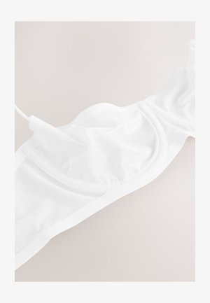 Baltos spalvos liemenėlė iš lengvos tinklelio medžiagos, su lygiomis kontūromis, reguliuojamais dirželiais ir besiūliu dizainu su minkšta elastine juosta.