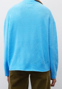 Pull en mélange de laine bleu avec un col et un ourlet côtelés, doté d'une coupe décontractée et d'une texture douce. Vu de dos.