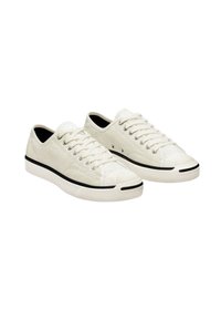 Zapatillas de lona blancas con una superficie texturizada, suela negra y detalles negros en la punta y el talón. Presenta siete ojales y cordones.