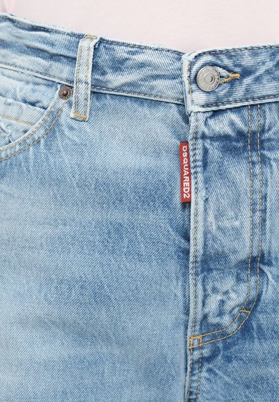 Light blue denim jeans featuring a button closure, yellow stitching, and a red label on the waistband. Distressed texture at the edges.