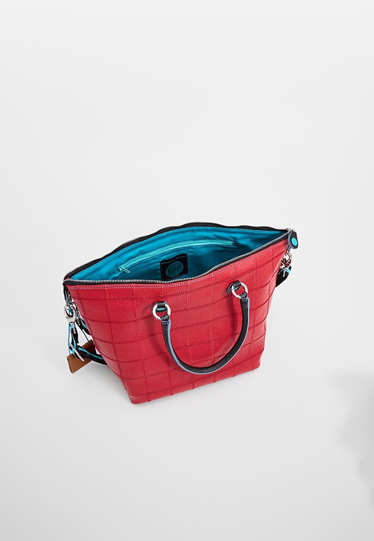 Bolso acolchado rojo con herrajes plateados, asas dobles, cierre de cremallera y un forro interior azul en contraste.