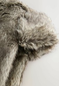 Faux fur garment in gray with soft texture. Features a hood and shaggy detail, showcasing varied lengths of the fur. Smooth inner lining.