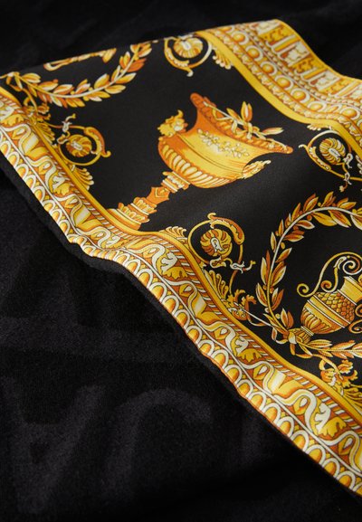 Jedwabny szal z czarnym tłem ozdobiony złoto-pomarańczowym wzorem w formie wazonów i motywów kwiatowych, obramowany misternymi detalami.