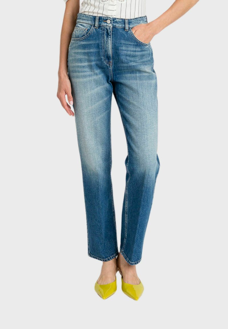 Jeans in denim blu a vita alta con una vestibilità comoda, dotati di tasche frontali e leggera sbiaditura, abbinati a tacchi a punta gialli.