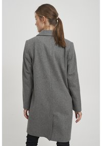 Cappotto in misto lana grigio con design sartoriale, colletto a punta e slit singolo sul retro. Maniche lunghe e silhouette di lunghezza media.