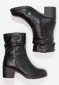 Bottes noires en cuir à talon épais, avec une fermeture éclair sur le côté, un haut froncé et une semelle texturée pour une meilleure traction.