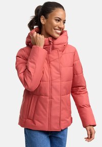 Veste matelassée à capuche de couleur corail, présentant un design matelassé, une fermeture éclair et des poches latérales. Texture lisse et coupe moderne.