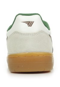 Sneaker con una toma in pelle bianca, dettagli in suede verde, rifiniture marroni e suola in gomma tassellata; presenta un logo distintivo sul tallone.