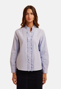 Blauw en wit gestreepte lange mouwen shirt met een gerimpelde placket aan de voorkant en subtiele oranje lijnen. Bevat knoopsluitingen en een bandkraag.
