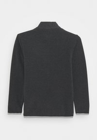 Grauer Pullover mit langen Ärmeln, hohem Kragen und geripptem Muster, das eine einfarbige Gestaltung mit einem kontrastierenden Saumdetail am unteren Rand aufweist.