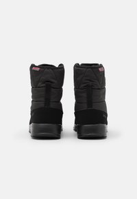 Botas de tobillo negras aisladas con parte superior acolchada, suelas de goma negra sólida y lengüetas de tirón. Textura suave y diseño minimalista.