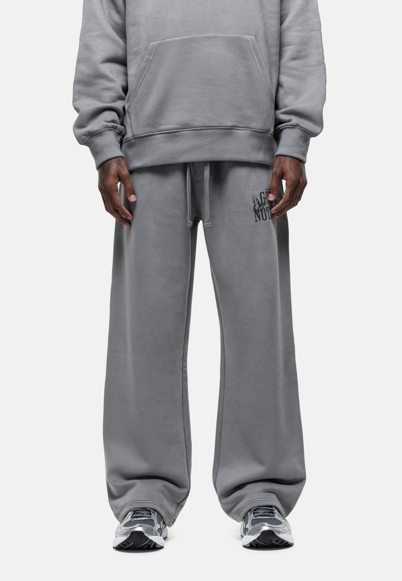 Szary sweatshirt i pasujące dresy wykonane z miękkiego materiału. Spodnie mają elastyczny pasek w talii i logo na lewej udzie. Luźny krój.