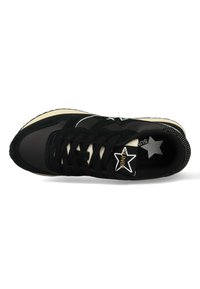 Sneaker nera con una combinazione di materiali scamosciati e sintetici. Presenta un logo a forma di stella bianca, lacci neri e una suola color crema.