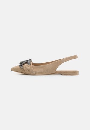 Ballerine in camoscio beige con punta affusolata, delicato dettaglio a fiocco e hardware decorativo sulla tomaia. Suola piatta e design aperto sul retro.