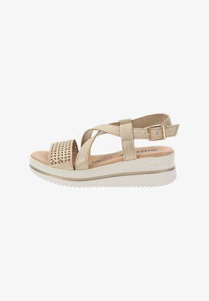 Sandales beiges avec un design ajouré sur la sangle, une boucle réglable et une semelle plateforme blanche avec une finition texturée.