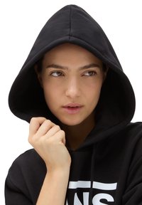 Felpa nera con cappuccio, dotata di una grande tasca frontale e logo bianco. Presenta una texture morbida, cappuccio con cordini e un design aderente attorno al viso.