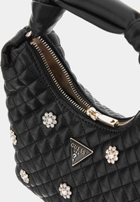 Borsa a tracolla nera trapuntata con hardware dorato, caratterizzata da decorazioni floreali e un logo di marca triangolare. Chiusura con zip sulla parte superiore.
