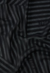 Tissu noir et gris foncé avec des rayures verticales et diagonales, une texture subtile, et un texte "BOSS" discret visible à deux endroits.