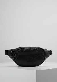 Czarna saszetka na pas, wykonana z błyszczącego, teksturowanego materiału. Posiada kieszeń z zamkiem błyskawicznym z przodu, regulowany pasek oraz kwadratową naszywkę z logo.