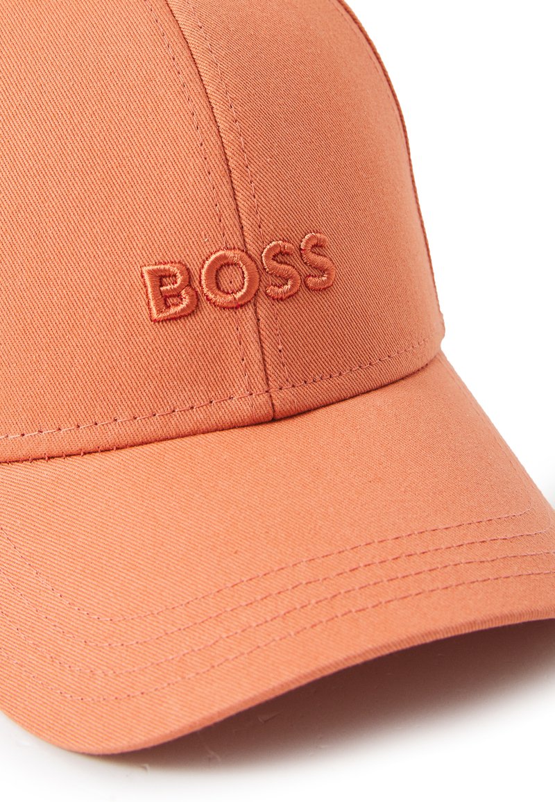 Czapka baseballowa w koralowo-pomarańczowym materiale z haftowanym logo "BOSS" w dopasowanym kolorze. Posiada usztywniony daszek i akcenty w szwie.